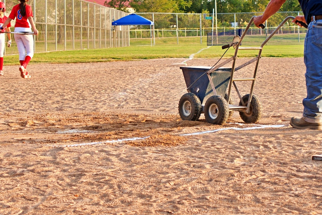 En groundsman i færd med at opkridte streger på en baseballbane.